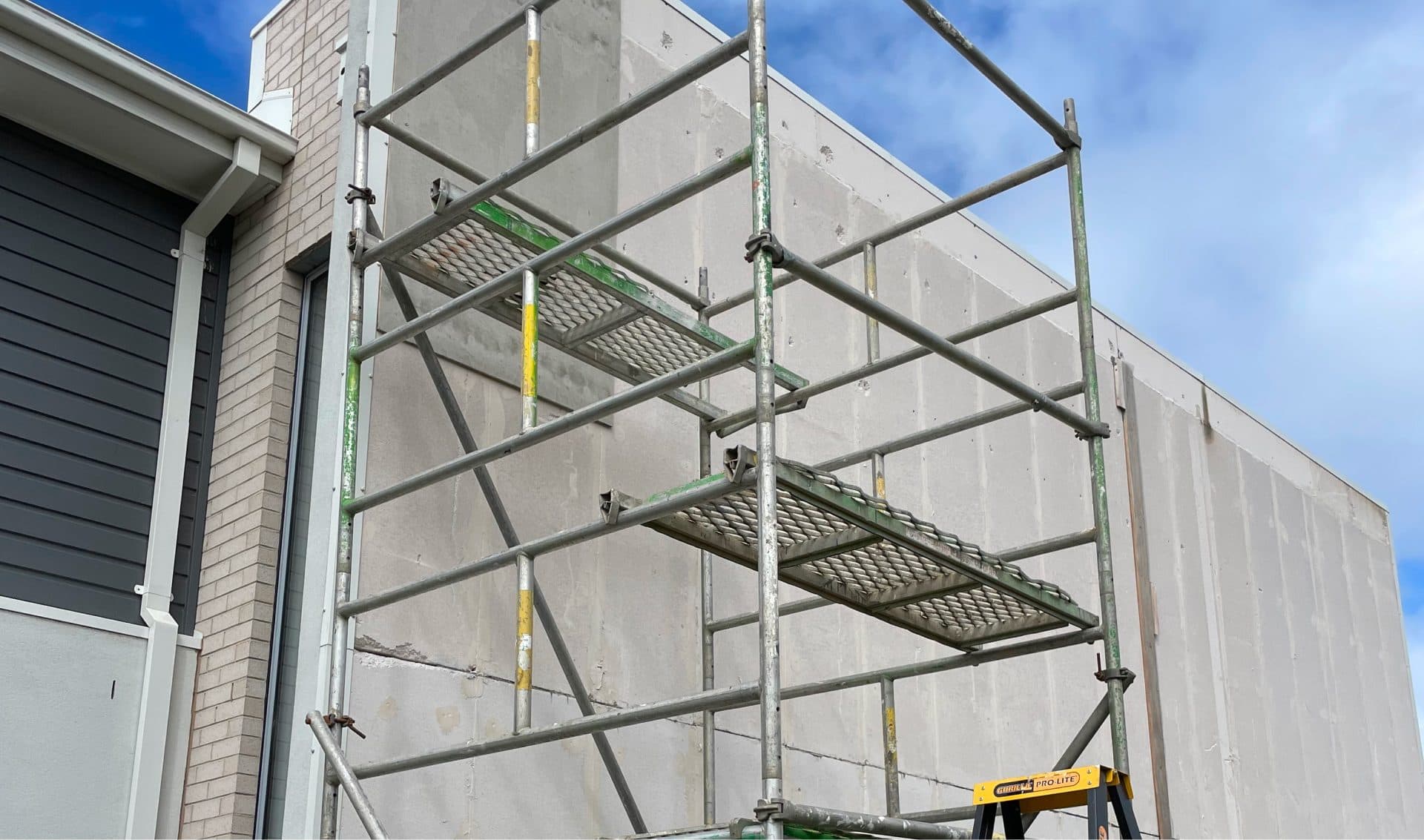 Scaffolding set up against a rendered wall for exterior work